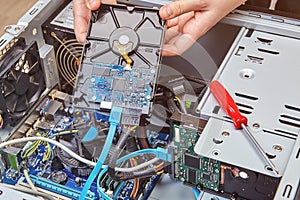 Removing computer hard drive from system unit to replace it with new one.