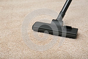 Removing dirt from carpet with modern vacuum cleaner indoors