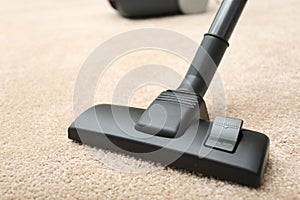 Removing dirt from carpet with modern vacuum cleaner indoors, closeup