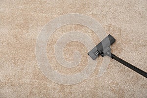 Removing dirt from carpet with modern vacuum cleaner indoors. Space for text