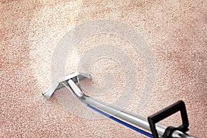 Removing dirt from carpet with professional cleaner indoors