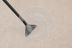 Removing dirt from carpet with vacuum cleaner indoors, closeup.