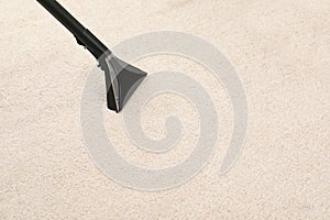 Removing dirt from carpet with vacuum cleaner indoors, closeup.