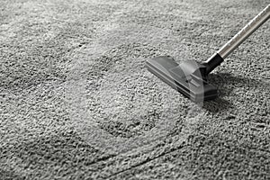 Removing dirt from grey carpet with vacuum cleaner