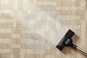 Removing dirt from light carpet with vacuum cleaner, top view