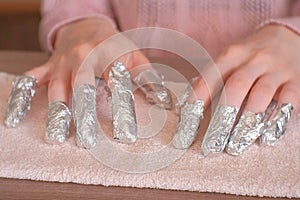 Removing gel Polish from nails. All fingers with foil on both hands. Close-up hand. Front view.