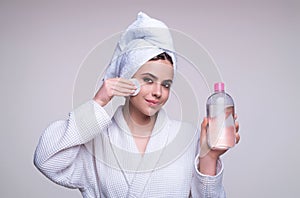 Removing makeup with cotton pads. Cleaning face with pad. Cosmetic cotton pad. Young woman caring for facial skin using