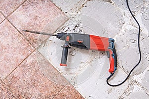 Removing old tiles. Jackhammer - drilling demolition hammer on floor