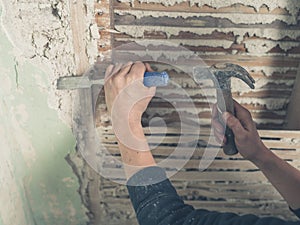 Removing plaster with hammer