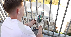 Removing rust and paint from balcony railings using angle grinder