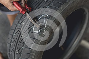 Removing a screw lodged into a tire with a pair of pliers. Fixing and vulcanizing a flat tire