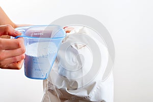 Removing stain from white shirt measuring determent by hand