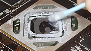 Removing thermal paste with cotton from heatsink. Close up macro