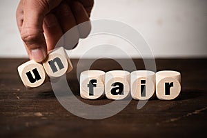 Removing two blocks with letters to change the word unfair to fair photo