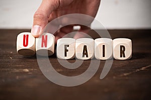 Removing two blocks with letters to change the word unfair to fair photo