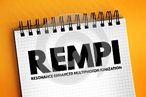 REMPI - resonance-enhanced multiphoton ionization acronym text on notepad, abbreviation concept background