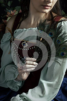 A Renaissance or Fantasy/fairytale/gypsy woman wearing a red brocade corset and blue silk skirt