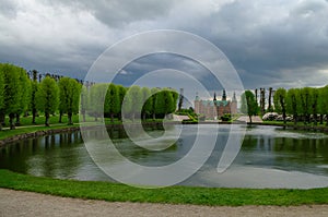 Renaissance Frederiksborg Castle on the island.  Pond in Castle`s garden on foreground. Hillerod, Denmark