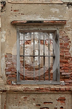 Rendered concrete wall with exposed red brick and wooden jail cell like window abstract