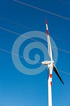 Renewable energy - Red and white wind turbine and a power line