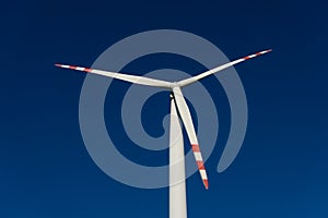 White blades of a wind turbine against the background of a navy blue sky. photo