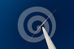 White blades of a wind turbine against the background of a navy blue sky. photo