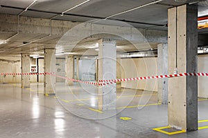 Renewed underground car parking with yellow lot marking and warning tape photo
