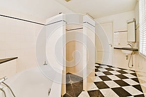 a renovated bathroom with white tiles and black and white