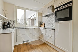 a renovated kitchen with white cabinets and a window