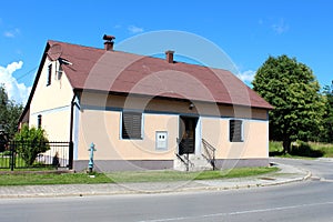 Renovated small suburban family house with new facade and newly painted black wrought iron fence located on street corner