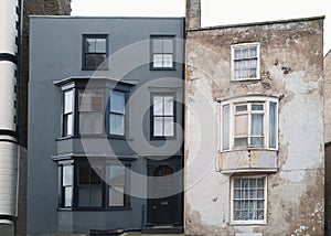 A renovated three floor town house  alongside a similar building before restoration