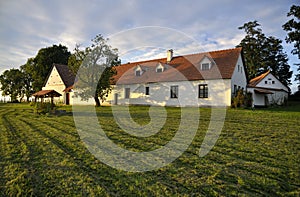 Renovated village homestead surrounded by grass field and trees