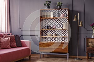 Renovated wooden bookcase with geometrical pattern and a brass f photo