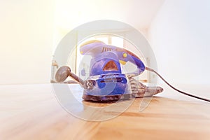 Renovating at home: sander tool for refreshing and grinding the wooden parquet floor photo