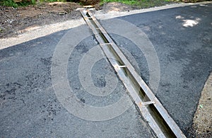 Renovation of asphalt road in the mountains. The ditches are filled with stones to slow down the water flowing out of the metal gr