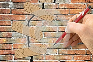 Renovation of an old brick wall - concept image with hand writing and adhesive bandage