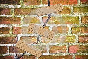 Renovation of an old cracked brick wall - concept image with bandaid patch