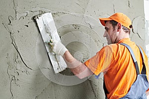 Renovation. Plasterer putting plaster on wall.