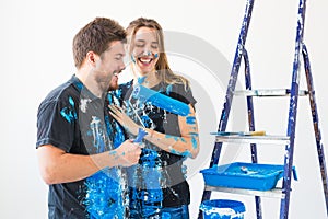 Renovation, redecoration and people concept - Portrait of couple stained with paint over white background