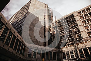 Renovation of residential building exterior. Construction site. Scaffoldings on apartment house facade. High rise modern