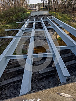 Renovation of a small old bridge. Steel girders painted and in good condition lying on rotten and rotten wooden sleepers