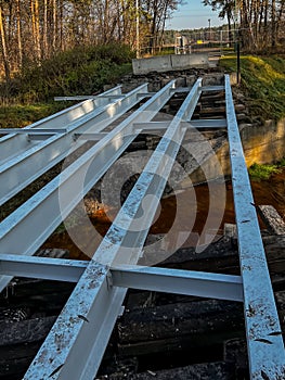 Renovation of a small old bridge. Steel girders painted and in good condition lying on rotten and rotten wooden sleepers