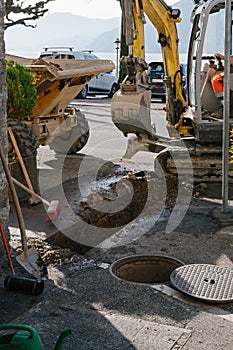 Renovation work. Hydraulic digger breaking up a road in Bissone. Canton Ticino. Switzerland