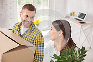 Cheerful merry couple coming in apartment