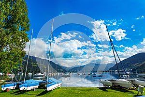 Rent-a-boat service in park at Zeller See lake. Zell Am See, Austria, Europe. Boats on shore and in water. Alps at background.