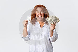 Rent, buying property and real estate concept. Excited and happy winning redhead middle-aged woman finally got money for