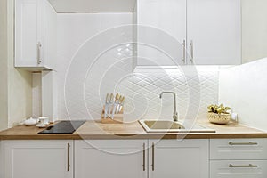 Rent of modern housing sale of new apartment, modern renovation. White furniture with utensils, shelves with crockery and plants