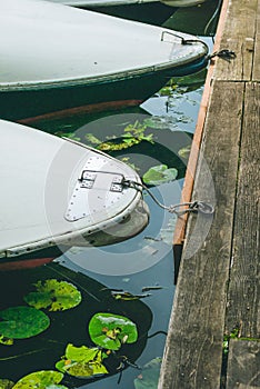 Rent rowboat anchored at the pier of a lake in city park. Hamburg