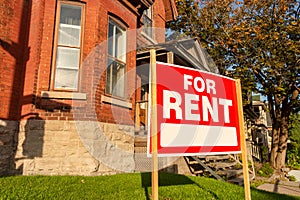 For rent sign posted in front of house photo