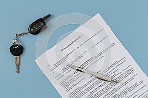 Rental agreement for a car with contract, pen and keys. Concept of selling, renting and insuring a car.